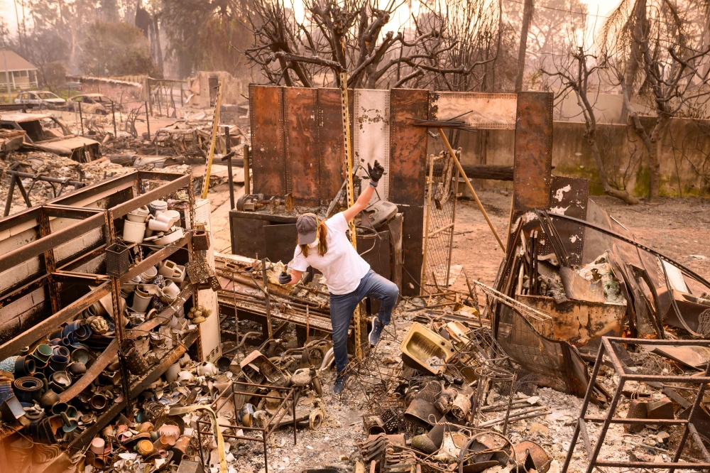 Tina Haworth walks through the remains of her burned home during the Eaton fire in the Altadena area of Los Angeles county. — AFP