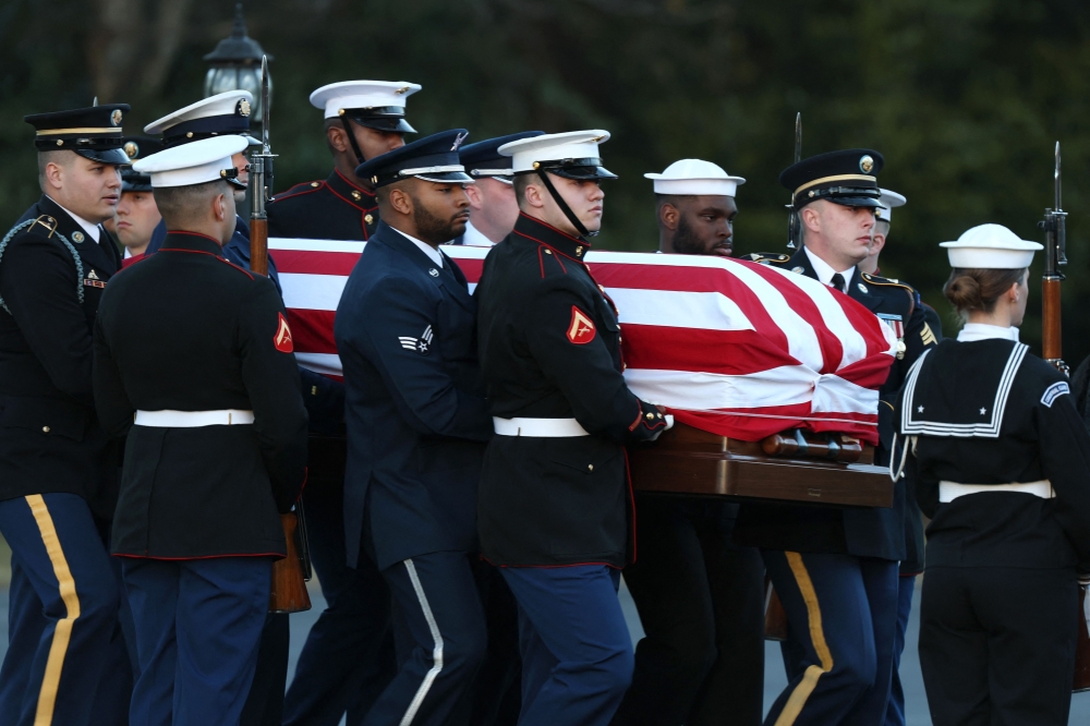 US Military Body Bearers carry the flag-draped casket bearing the remains of former US President Jimmy Carter into Maranatha Baptist Church for his funeral service. — AFP