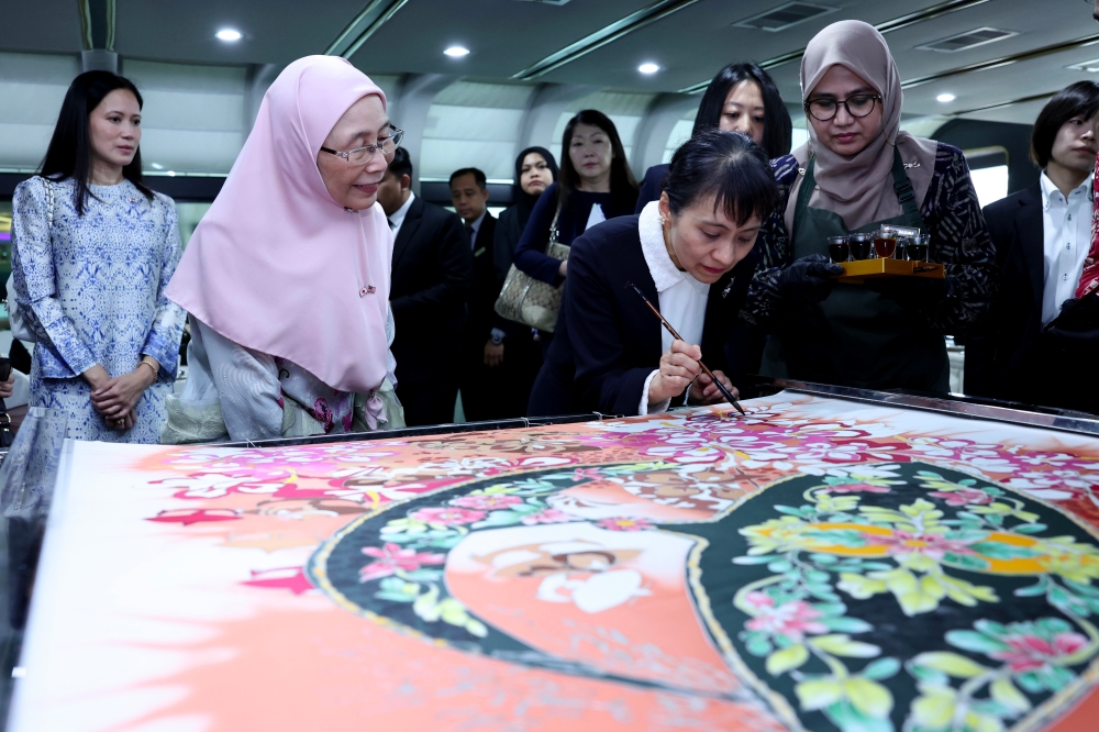 Japan Prime Minister Shigeru Ishiba's wife, Yoshiko Ishiba, tries her hand at batik painting in Putrajaya January 10, 2025. — Bernama pic