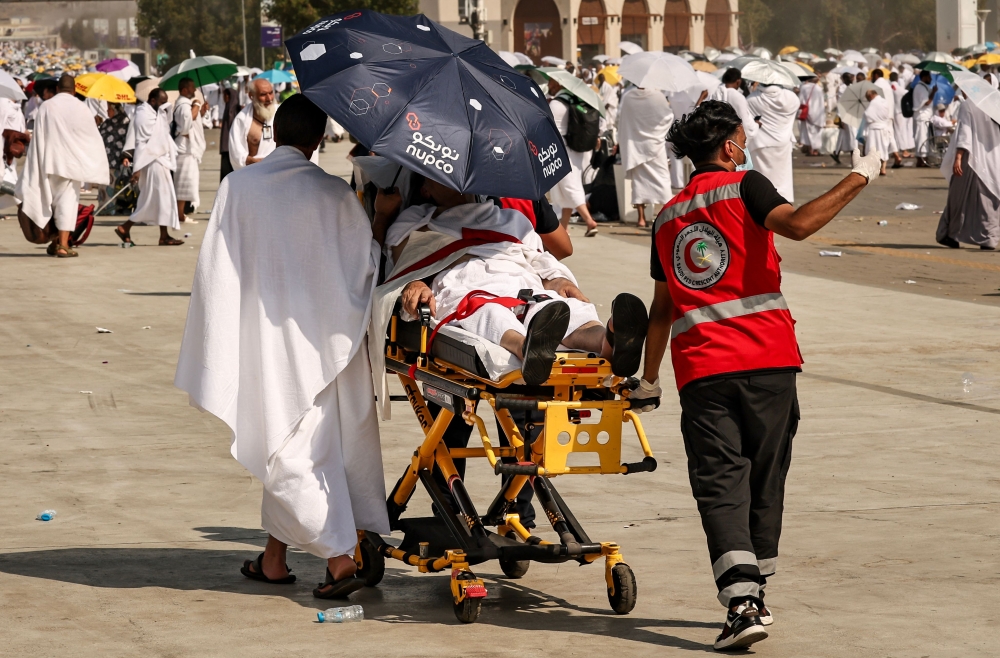 Medical team members evacuate a Muslim pilgrim, affected by the soarching heat, at the base of Mount Arafat, also known as Jabal al-Rahma or Mount of Mercy, during the annual hajj pilgrimage on June 15, 2024. — AFP pic