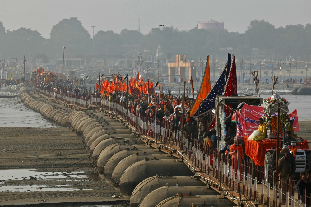 Hindu holy men or Sadhus walk in a religious procession of Atal Akhara across a floating pontoon bridge, ahead of the Maha Kumbh Mela festival in Prayagraj on January 1, 2025. — AFP pic