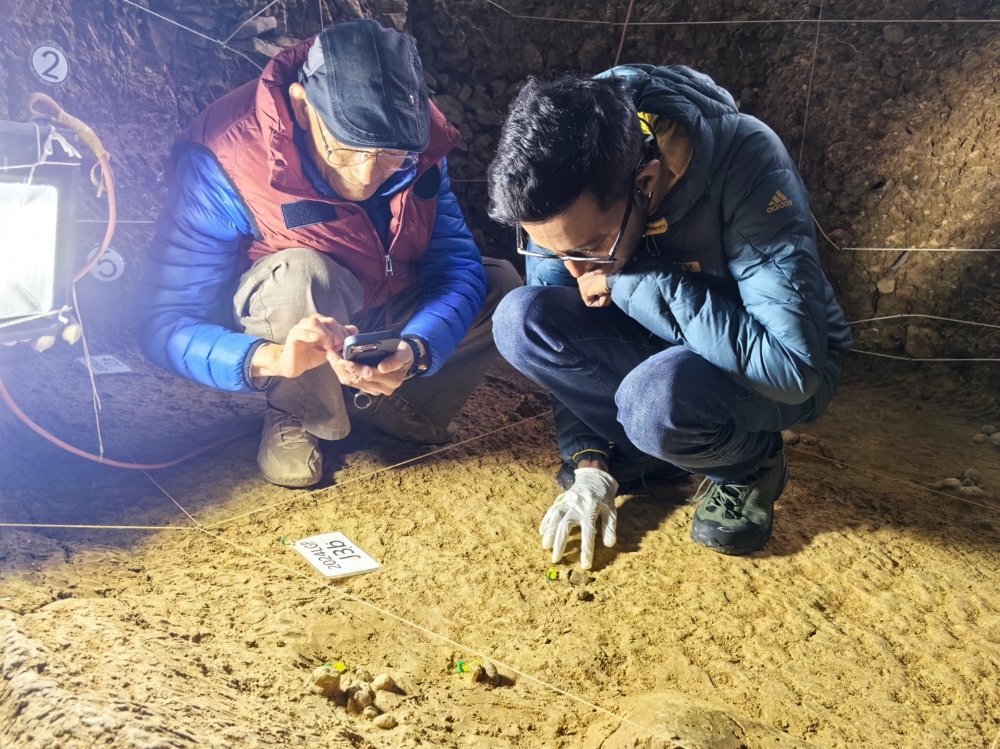 Malaysian fossil scientist Dr Paul Rummy, together with 93-year-old palaeontologist Dr Huang Wanpo, examines traces of two-million-year-old coprolites (fossilised excreta) at Longgupo, also known as Dragon Bone Cave, in Wushan, China. — Bernama pic