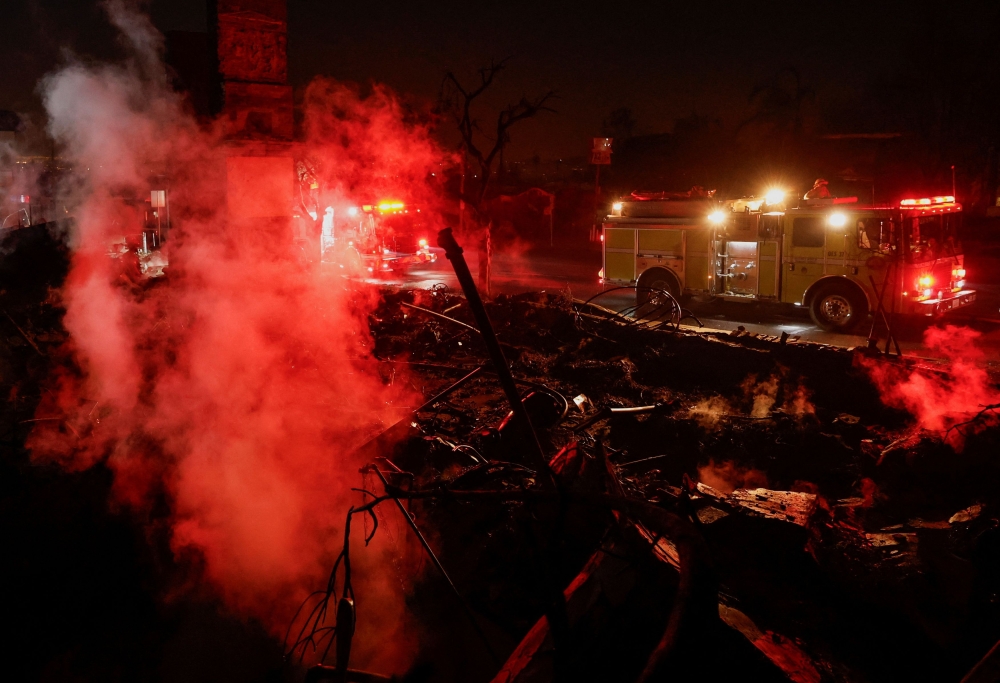 A firefighting truck is parked near a hotspot at a commercial building that burned down during the Eaton Fire, in Altadena, California, January 10, 2025. — Reuters pic