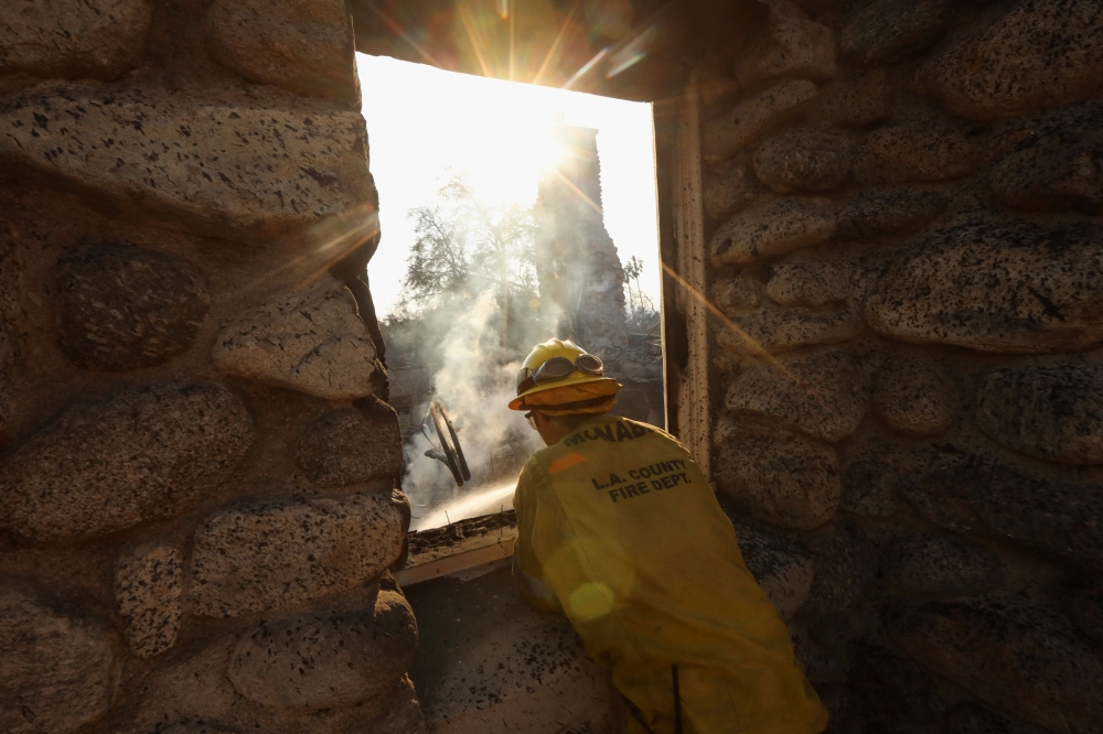 A firefighter surveys a hotspot, following the Eaton Fire, in Altadena, California, January 10, 2025. — Reuters pic