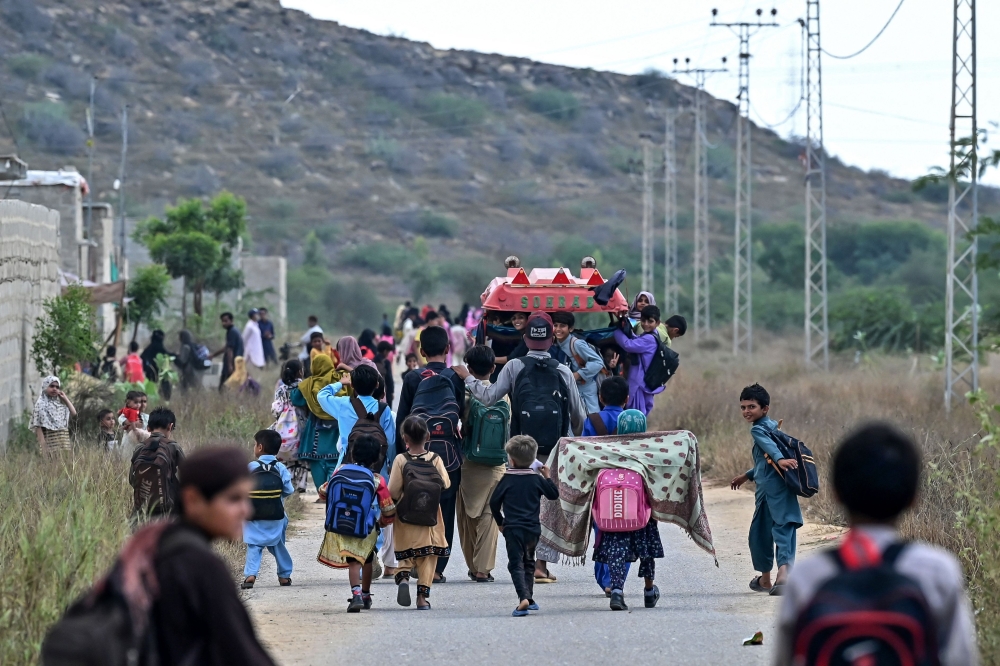 Students return home from a community school in Abdullah Goth village on the outskirts of Karachi November 13, 2024. — AFP pic