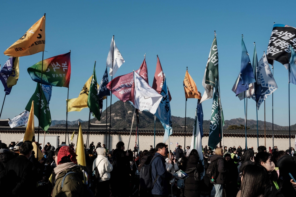 Protesters waving flags at the rally. — AFP