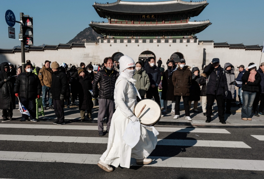 One of the protesters playing a drum. — AFP