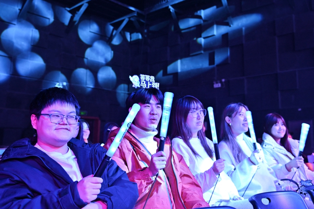 Spectators watch women gamers competing during an esport event in Beijing December 19, 2024. — AFP pic