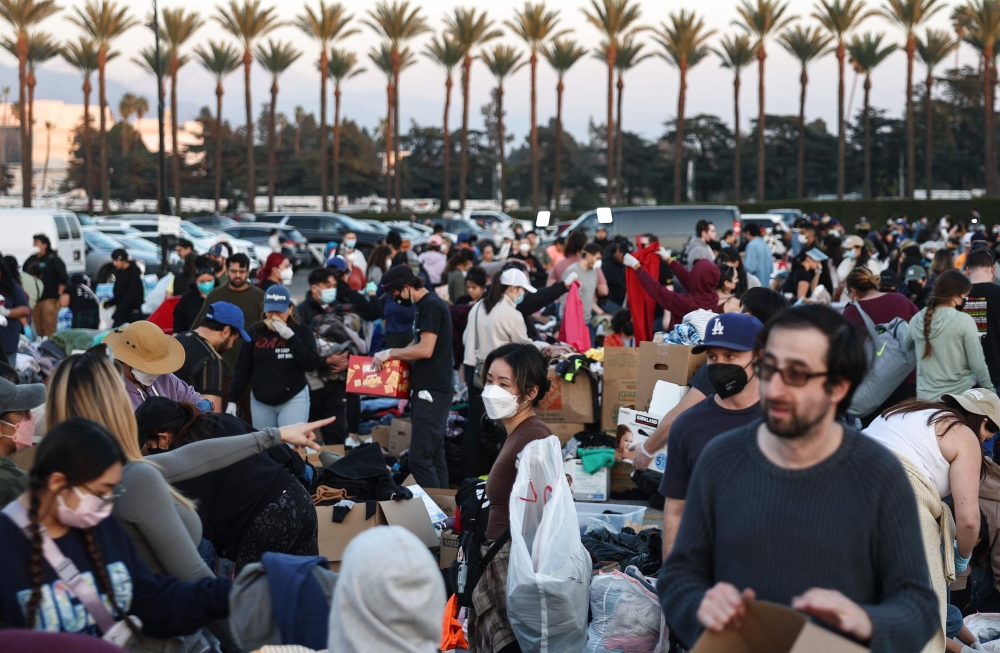 People gather and sort through donated clothing and other items at a pop-up donation center for wildfire victims at Santa Anita race track.  — AFP