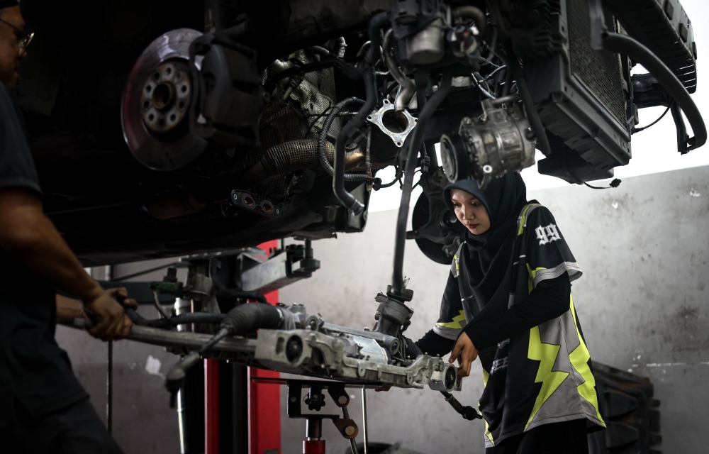 Khairin Qisstina conducts repairs on a car at MTH Autohaus & Accessories in Taman Pengkalan Jaya, Ipoh January 12, 2025. — Bernama pic