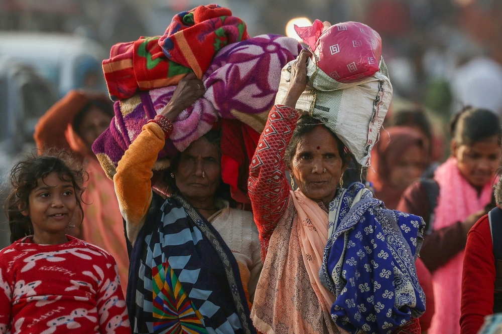 Hindu pilgrims carrying their belongings arrive at Sangam, the confluence of Ganges, Yamuna and mythical Saraswati rivers, ahead of the Maha Kumbh Mela festival in Prayagraj January 11, 2025. — AFP pic