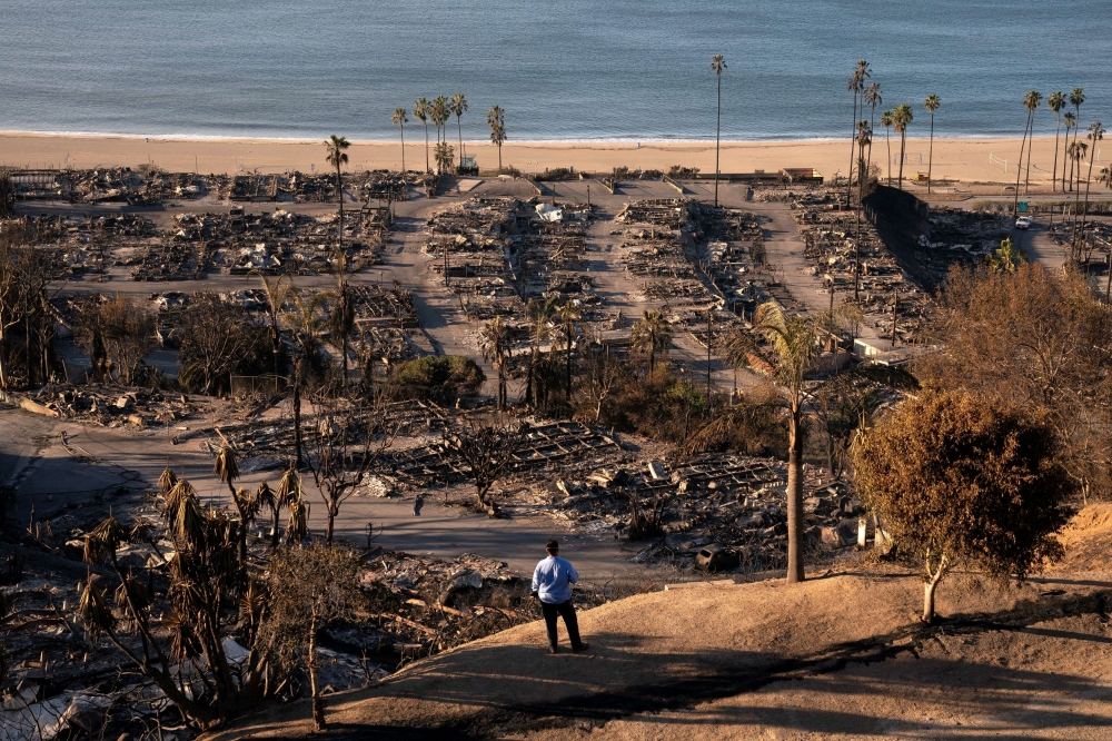 A utilities worker views damage from the Palisades Fire, in the Pacific Palisades neighbourhood in Los Angeles, California, US January 12, 2025. — Reuters pic