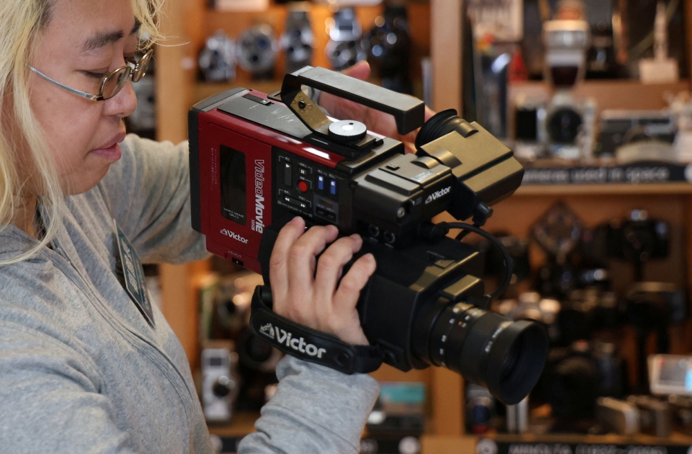 Deputy curator Barbara Asuka holds the VHS-C videocassette format camera at Extinct Media Museum in Tokyo, Japan January 11, 2025. — Reuters pic 