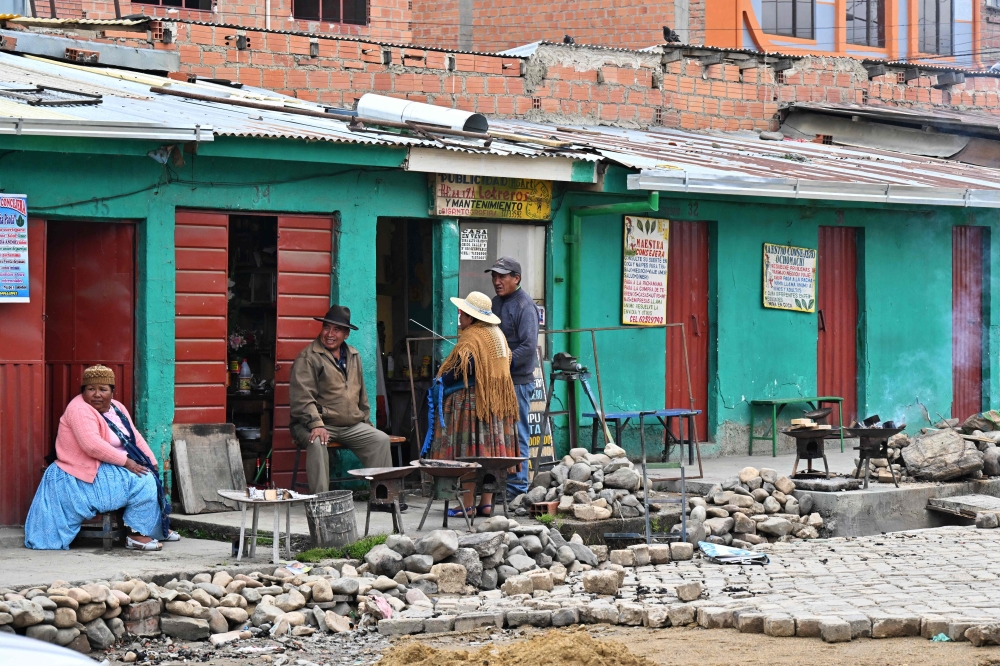 People remain outside coca leaf reading rooms at a market built on the edge of a cliff in the La Ceja area of the city of El Alto, Bolivia, on December 9, 2024. — AFP pic