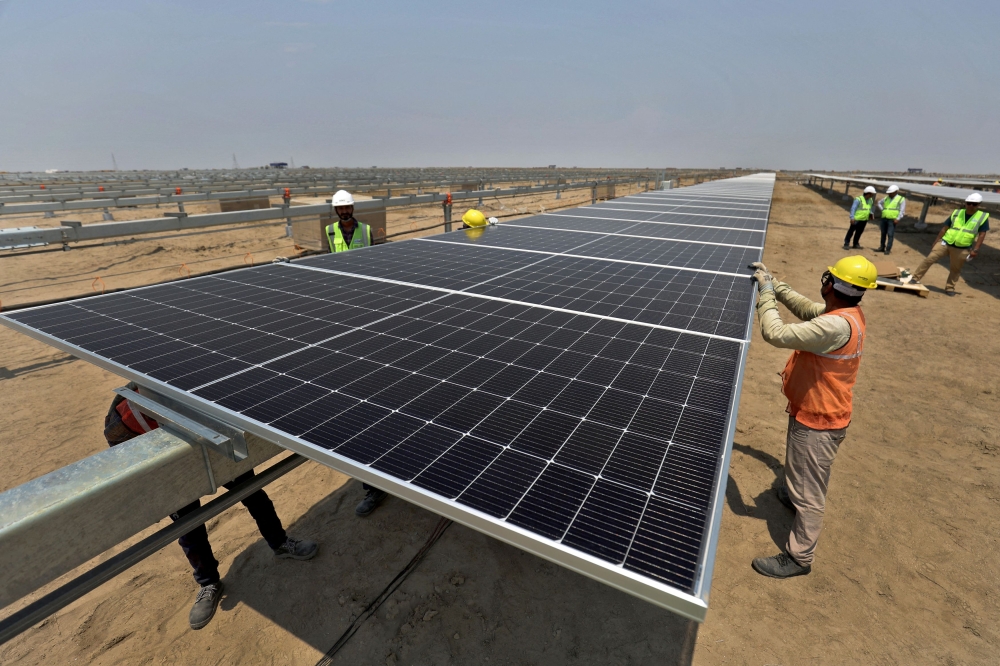 A file photograph shows workers installing solar panels in Khavda, India, April 12, 2024. — Reuters pic