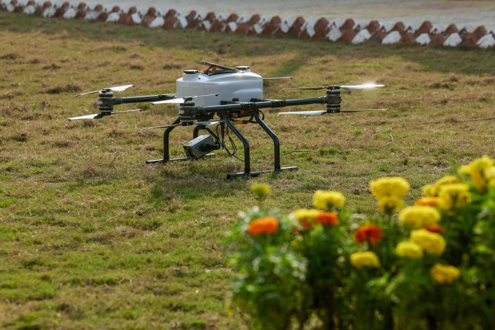 A drone equipped with artificial intelligence (AI), which enables the state police to surveil the crowd, lands on the ground during the Maha Kumbh Mela festival in Prayagraj. — AFP pic