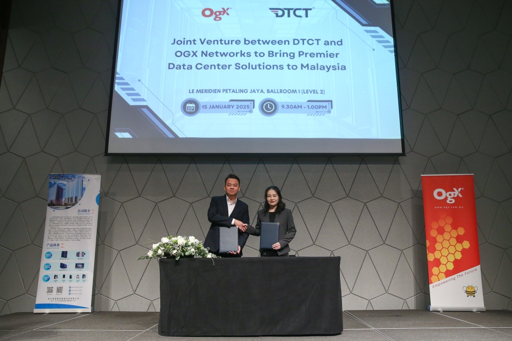 OGX Networks Sdn Bhd managing director Tan Suan Loong (left) and Vice President of DTCT Data & Technology Co. Ltd, Jiawa Lu at the joint venture signing ceremony. — Picture by Yusof Mat Isa