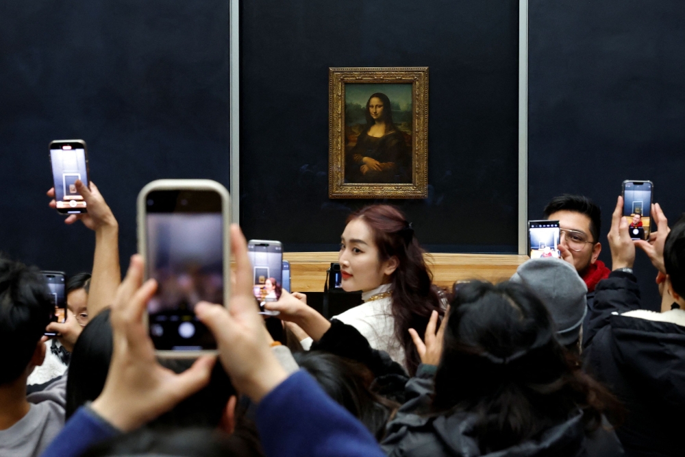 Visitors take pictures of Mona Lisa at the Louvre. — AFP pic