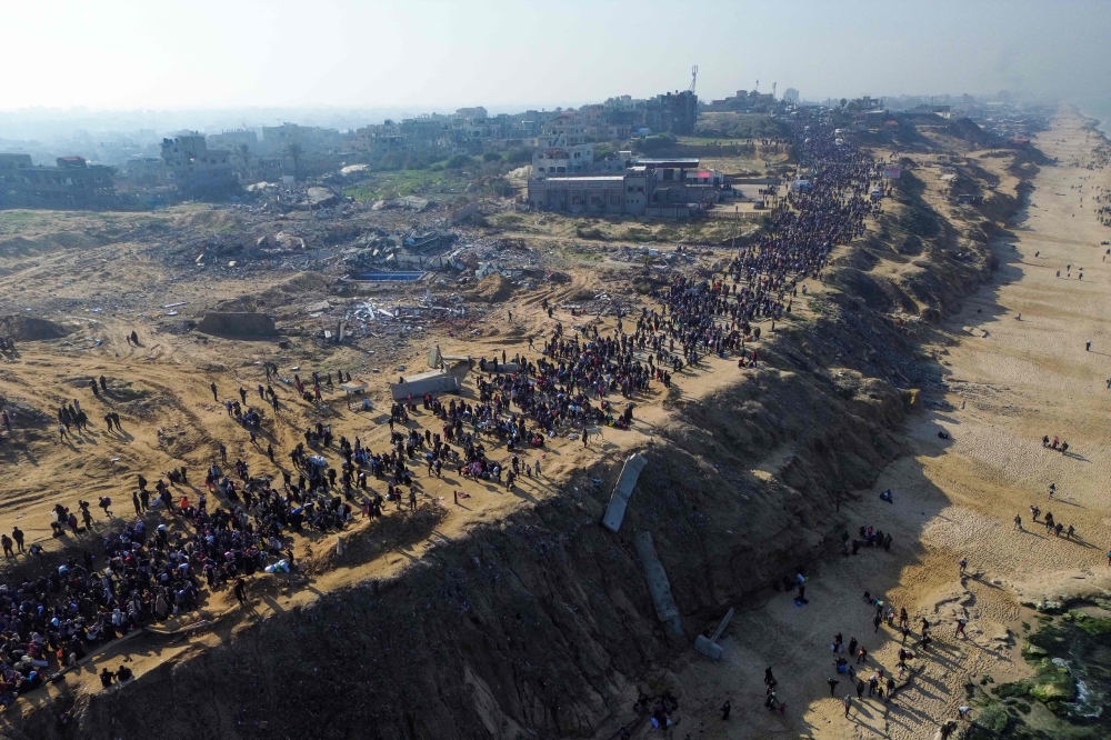 This aerial photo shows displaced Gazans walking toward Gaza City. — Pic by AFP