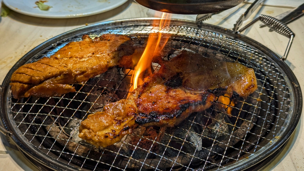 The marinated 'galbi' can flare up, due to sugars in the marinade. — Picture by Ethan Lau