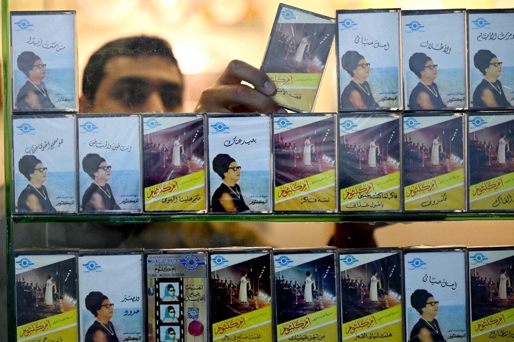 A man arranges audio tapes of Umm Kulthum songs at a music shop selling vintage items linked to the late Egyptian singer who passed away in February 1975. — AFP pic