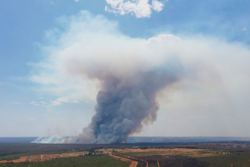 This aerial view shows smoke billowing from a forest fire affecting the Brasilia National Park in Brasilia on September 16, 2024. Brazil is suffering the effects of a multiplication of fires from north to south in the midst of an extreme drought linked to climate change. Rising global temperatures, melting ice caps, and extreme weather events are creating severe impacts on ecosystems, economies, and communities. — AFP pic