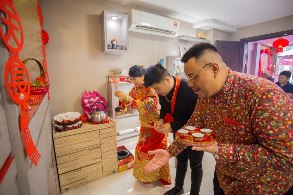 Chong guides a bridal couple through a prayer ceremony as they seek blessings from ancestors and deities for their nuptials. — Picture courtesy of Dary Chong