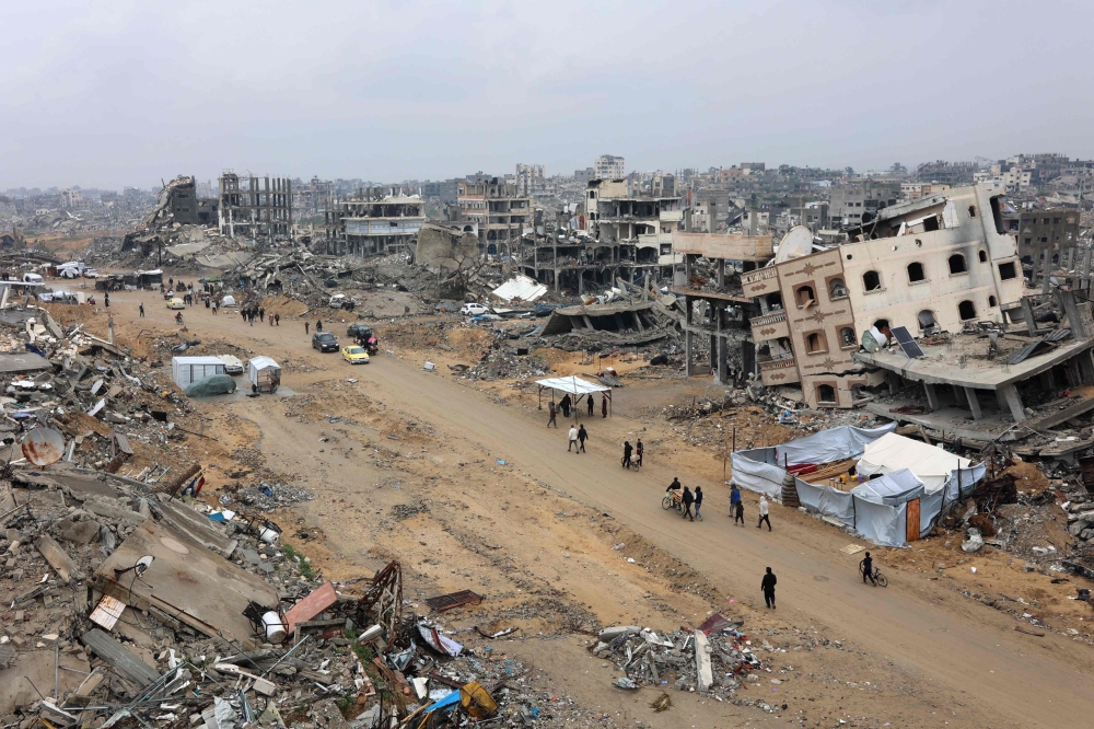 People walk amid collapsed buildings along Saftawi street in Jabalia in the northern Gaza Strip on February 5, 2025 during a ceasefire deal in the war between Israel and Hamas. — AFP pic