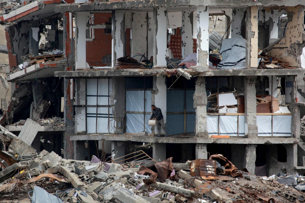 A Palestinian man clears debris on the first floor of a destroyed building in Jabalia in the northern Gaza Strip on February 5, 2025, during a truce in the war between Israel and Hamas. — AFP pic