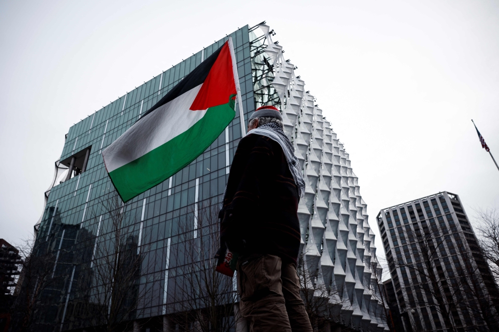 A protester waves a Palestinian flag in front of the US Embassy during a Pro-Palestinian march in central London, on February 15, 2025, organised by the Palestine Solidarity Campaign. — AFP pic