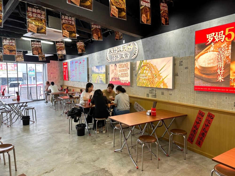 Luo Ma Claypot's decor has more attention to details like Chinese newspapers on the walls and retro wooden like tables and chairs — Picture by Lee Khang Yi