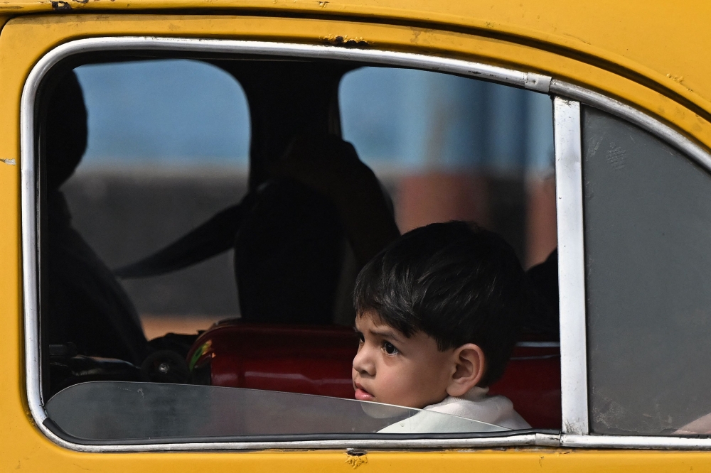 A child riding in a Hindustan Ambassador taxi in Kolkata. — AFP pic