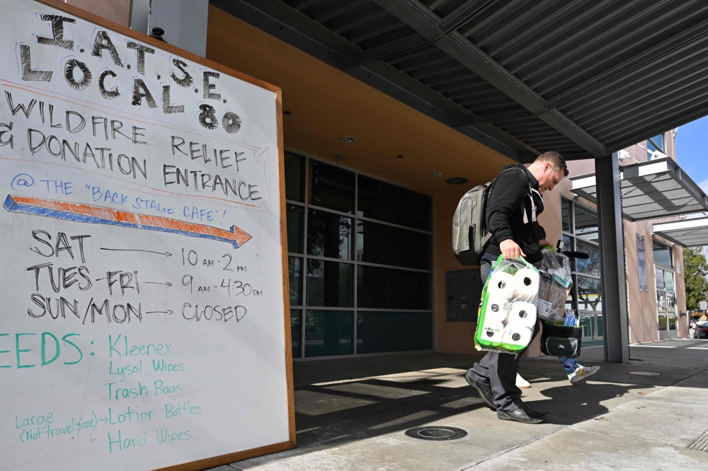 Dutch Merrick, a movie armorer who lost his Altadena home in the Eaton Fire, carries supplies he needed from a daily free food and sundries pantry provided for Hollywood film and television workers in need of assistance struggling after the devastation of the Southern California wildfires, on February 14, 2025 at the IATSE union hall in Burbank, California. — AFP pic