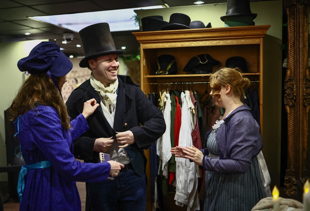 Visitors try on period clothing as they take a tour of the Jane Austen Centre in Bath, Somerset on February 14, 2025. — AFP