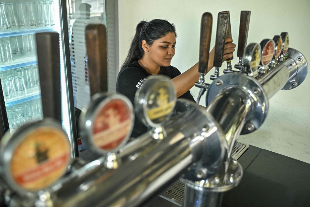 This photograph taken on February 20, 2025 shows Lynette Pires, a brewer, tapping beer at a brewery near Electronic City in Bengaluru. — AFP pic