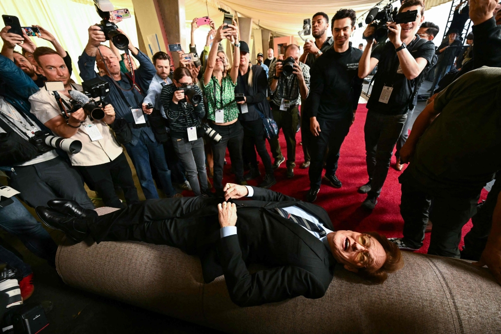 US comedian and this year's Oscars host Conan O'Brien lies on the red carpet for the Oscars arrivals area as it is rolled out along Hollywood Boulevard during preparations for the 97th Annual Academy Awards in Hollywood, California, on February 26, 2025. — AFP pic