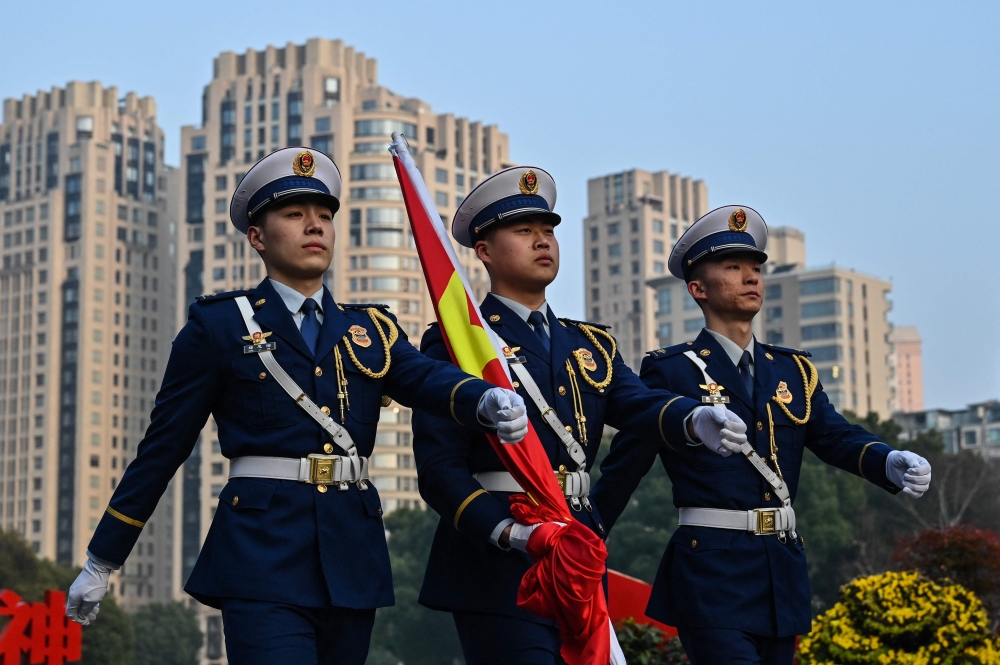 Honour guards walk as they carry China's flag next to the Museum of the First National Congress of the Chinese Communist Party in Shanghai on February 27, 2025. — AFP pic