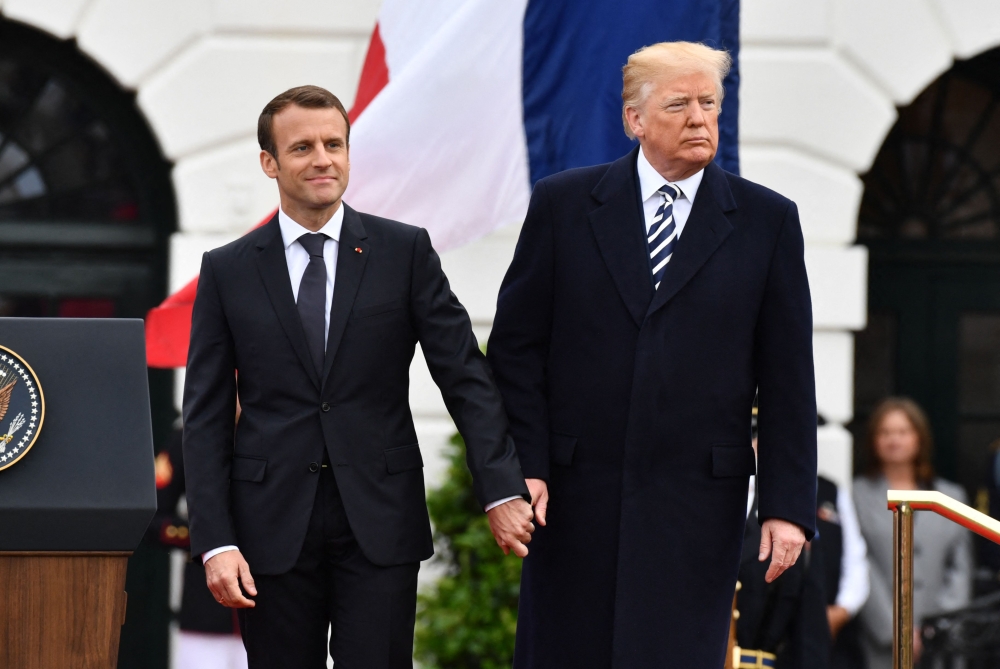 French President Emmanuel Macron and US President Donald Trump join hands during a state welcome at the White House in Washington, DC in this file photo taken on April 24, 2018. — AFP file pic