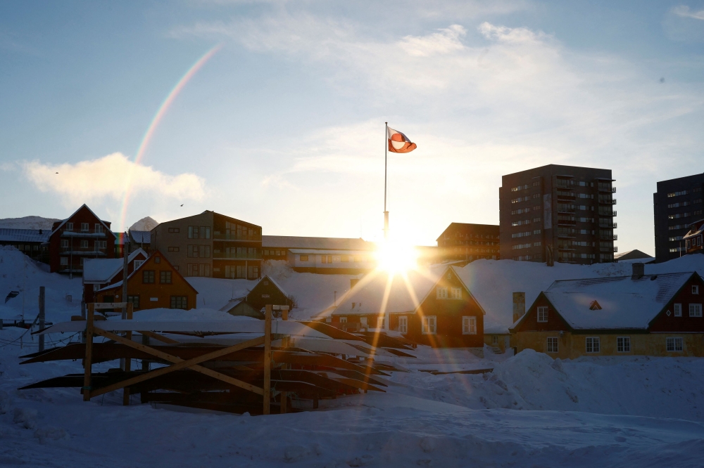 The sun rises behind Greenland's flag in Nuuk's old harbor, Greenland, February 5, 2025. — Reuters pic 